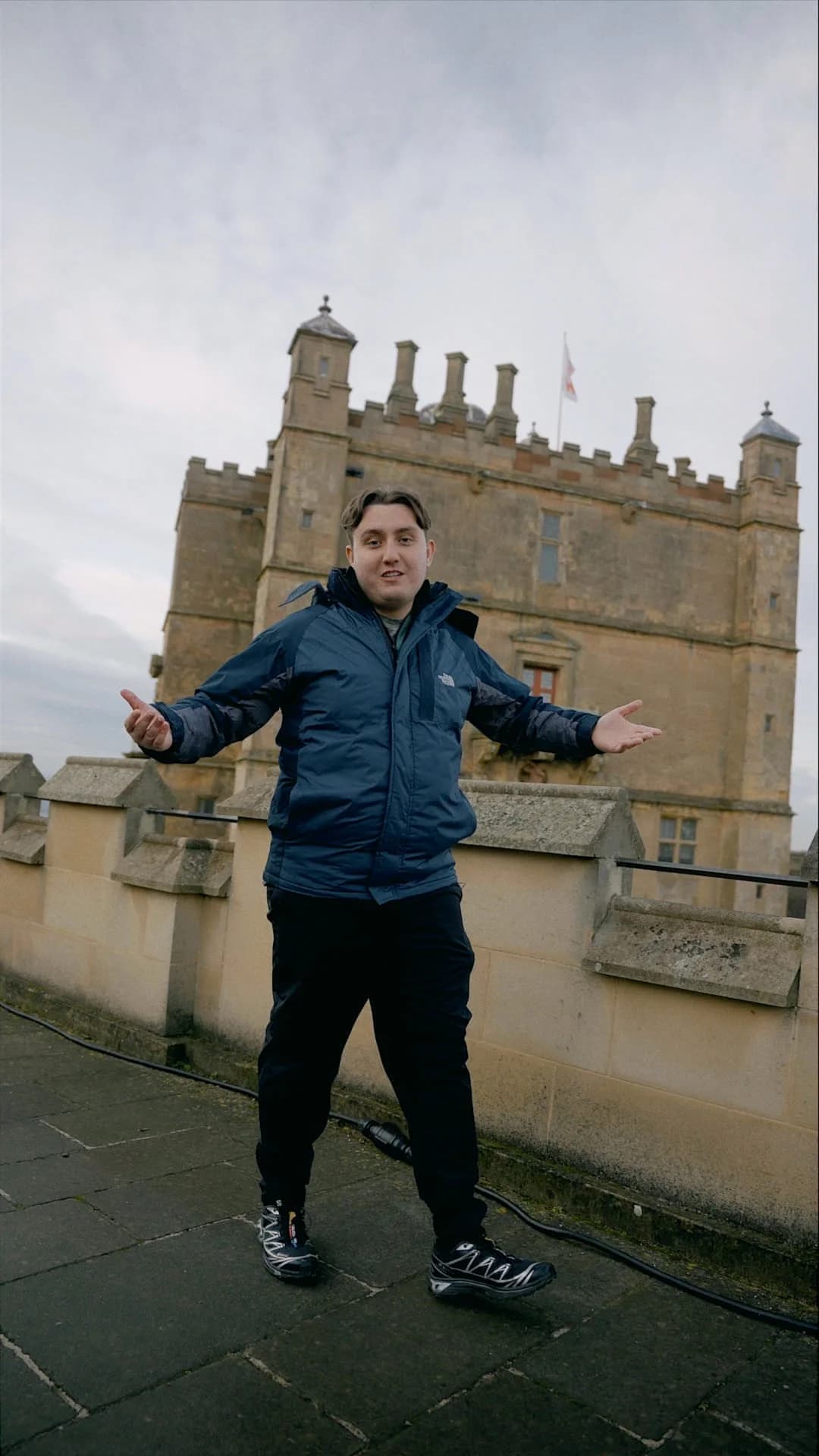 Joseph Roberts gesturing in front of a castle during the English Heritage project