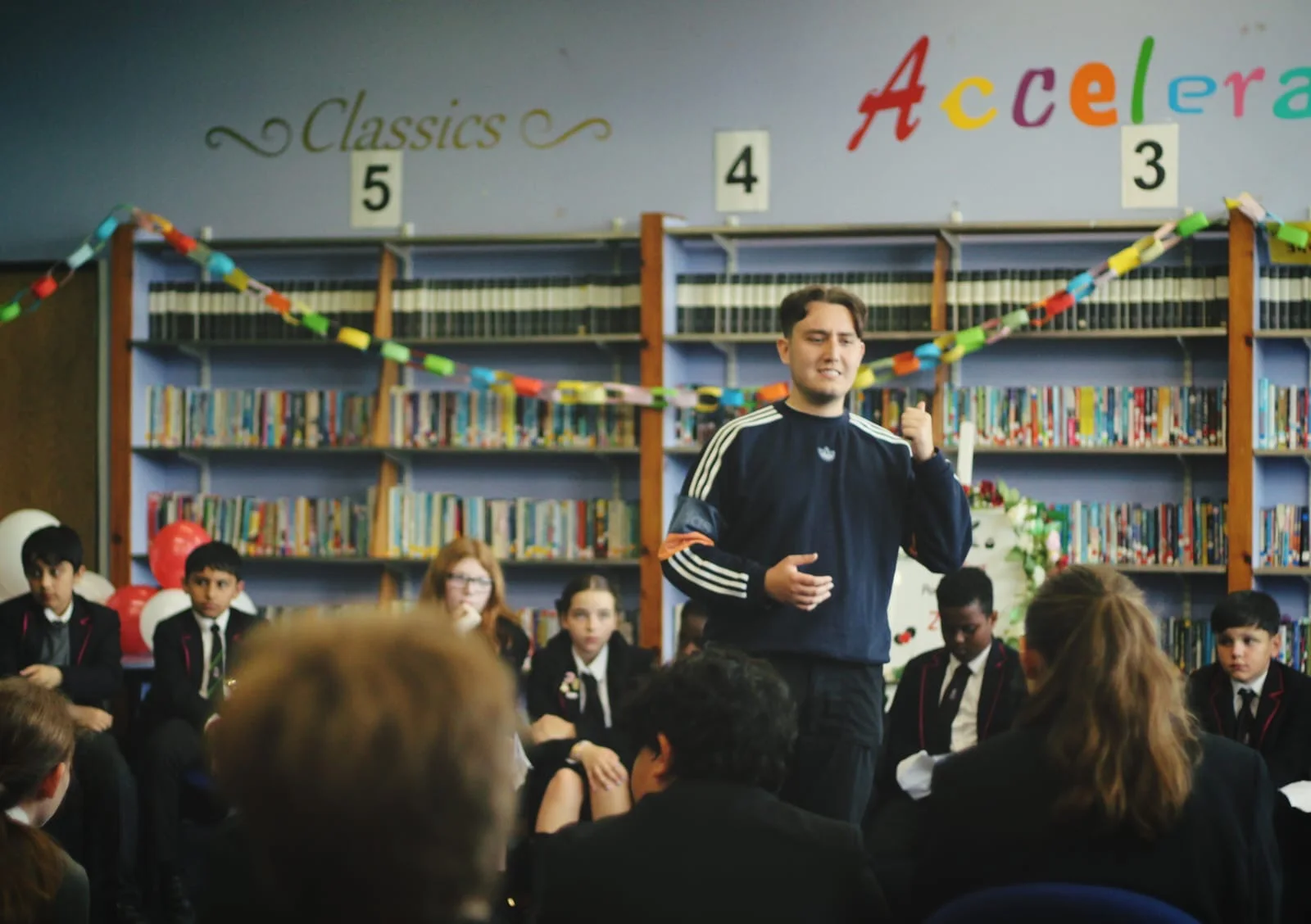 Pupils listening to Joseph Roberts during a school library session