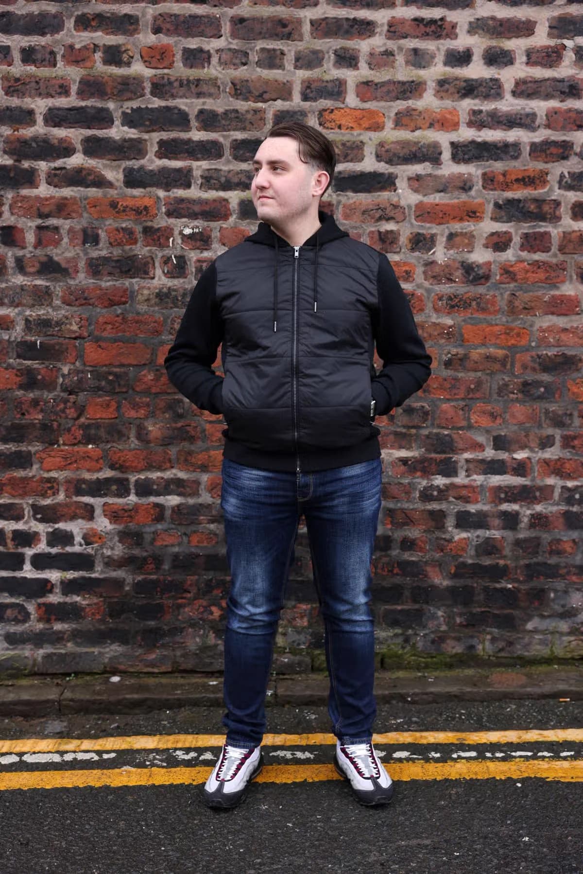 Joseph Roberts standing against a Liverpool brick wall