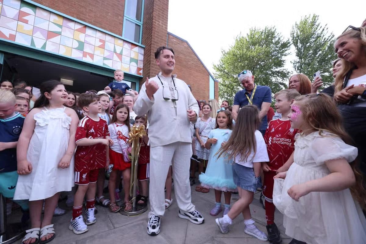 Joseph Roberts surrounded by children during a Liverpool community school event