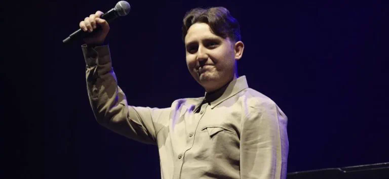Joseph Roberts holding a microphone aloft during a live performance