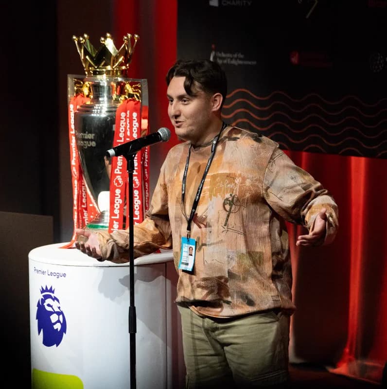 Joseph Roberts performing beside the Premier League trophy
